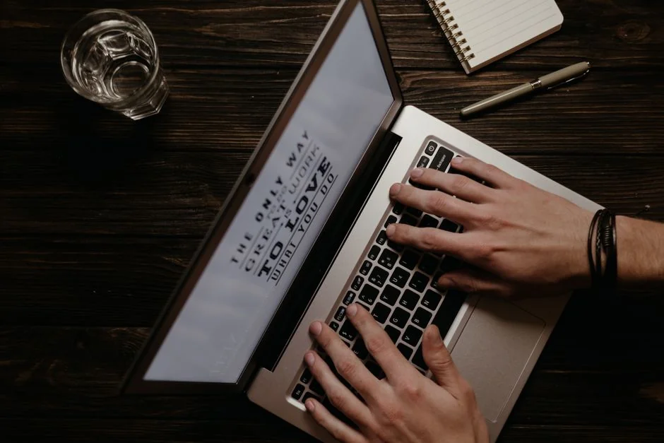 Flat lay of keyboard letter tiles spelling email on coral backdrop.